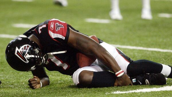 Falcons quarterback Michael Vick holds his leg after being injured in the first quarter of an exhibition game Saturday, Aug. 16, 2003, against the Baltimore Ravens in Atlanta.