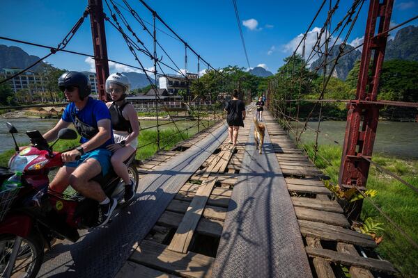 Foreign tourists roam around in Vang Vieng, Laos, Friday, Nov. 22, 2024. (AP Photo/Anupam Nath)