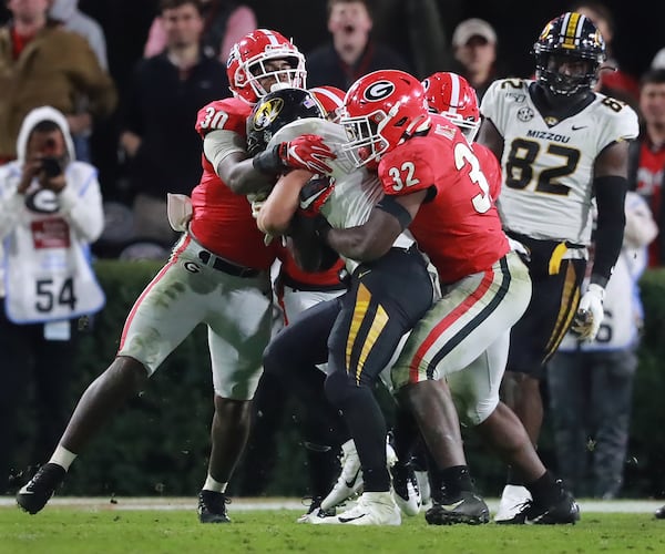 Georgia inside linebackers Monty Rice (right) and Tae Crowder (left) tackle Missouri running back Dawson Downing.   Curtis Compton/ccompton@ajc.com