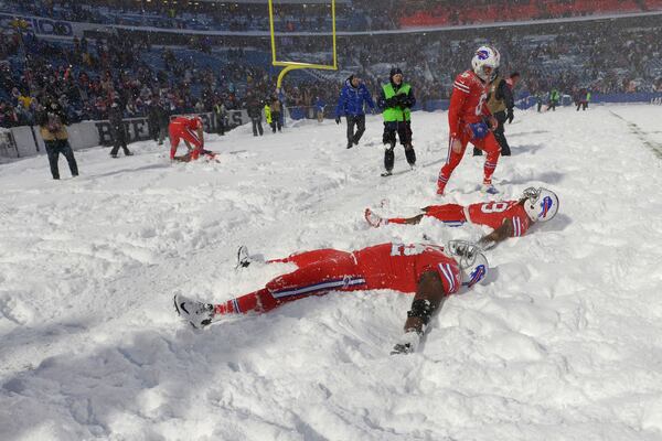 Buffalo Bills players make snow angels after beating the Indianapolis Colts after an NFL football game, Sunday, Dec. 10, 2017, in Orchard Park, N.Y. The Bills beat the Colts in overtime 13-7. (AP Photo/Adrian Kraus)