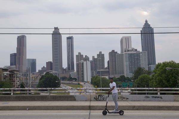 A man rides an electric scooter along the Jackson Street bridge in downtown Atlanta, Monday, May 14, 2018. ALYSSA POINTER/ATLANTA JOURNAL-CONSTITUTION