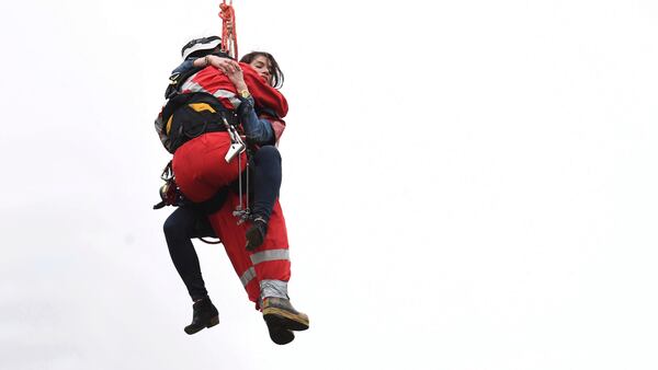 A woman is rescued from a downtown Toronto crane early Wednesday, April 26, 2017. Some streets in the downtown core were closed as dozens of construction workers and commuters gazed skyward to watch police and firefighters try to rescue the woman who got stuck atop the tall construction crane. (Frank Gunn/The Canadian Press via AP)