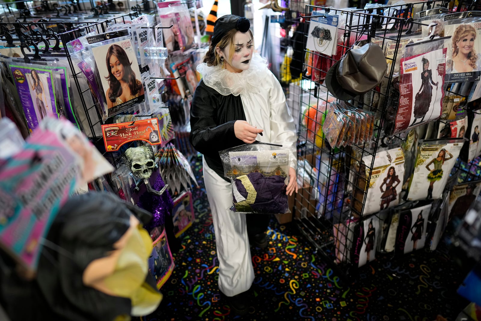 Olive Luther stocks costume displays at The Theatrical Shop, Tuesday, Oct. 29, 2024, in West Des Moines, Iowa. (AP Photo/Charlie Neibergall)