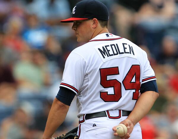 September 3, 2012 - Atlanta, Ga: Atlanta Braves starter Kris Medlen looks back at the Colorado Rockies runner on first base in the 7th inning of his complete one run win over the Colorado Rockies at Turner Field in Atlanta, Ga., September 3, 2012. Medlen had 12 strike outs in the game. The Braves defeated the Rockies 6-1. JASON GETZ / JGETZ@AJC.COM Tuesday is the deadline for teams to offer contracts to their unsigned players, and the Braves have decisions to make with pitchers Kris Medlen (pictured) and Brandon Beachy, each coming back from his second Tommy John elbow surgery.