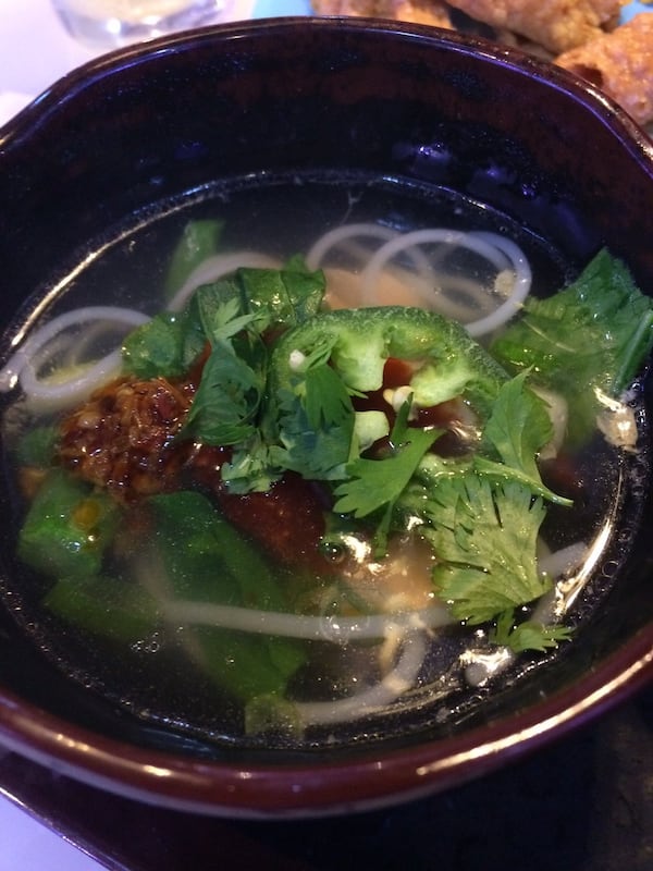 A bowl of beef broth at I Luv Hot Pot is filled with a pho-like mix of noodles and garnished with cilantro, green onion and minced garlic in chile oil. CONTRIBUTED BY WENDELL BROCK