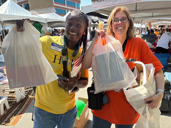 An overjoyed teacher (right) is able to grab free Black History books for her class at last year's Juneteenth celebration at the Marietta Square. She is being helped by a North River HOPE Worldwide volunteer. Photo courtesy of North River HOPE Worldwide