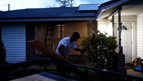 Matt Cronin works into the night to secure plywood to his home's windows before fixing dinner for his children as residents in the area prepare ahead of Hurricane Irma  in Merritt Island, Florida.