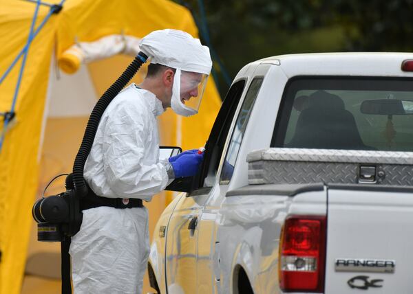 A medical professional in protective equipment collects a sample from a potential COVID-19 patient at a Phoebe Putney Health System drive-thru testing site in Albany, Georgia, on March 24, 2020. (Hyosub Shin / Hyosub.Shin@ajc.com)