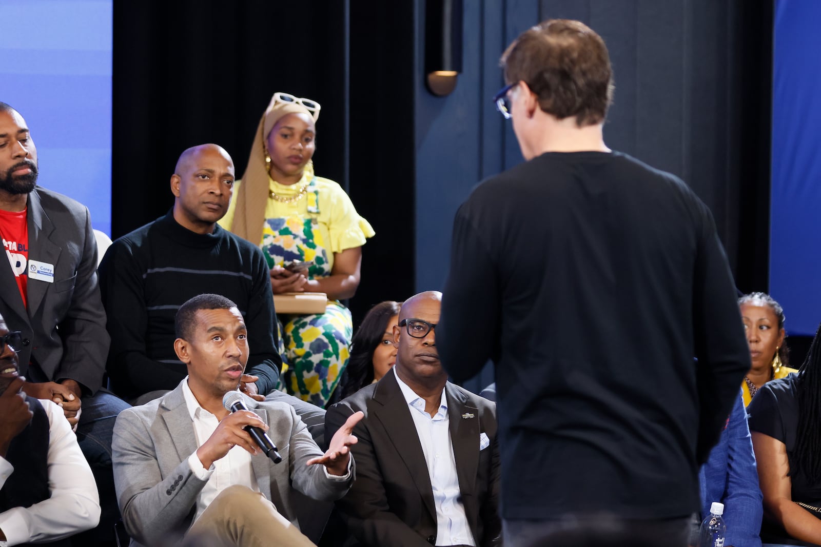 A audience member at the Gathering Spot asks billionaire and investor Mark Cuban a question about Vice President Kamala Harris' economic policies during a town hall meeting Thursday. (Miguel Martinez / AJC)