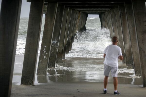 TYBEE ISLAND, GA - AUGUST 30, 2023: Longtime resident Ernie Laessig watches the waves from Hurricane Idalia crash under the Tybee Pier; as the storm intensifies along the coast, Wednesday, Aug. 30, 2023, in Tybee Island, Ga. The system remained a hurricane as it crossed into Georgia with top winds of 90 mph after drenching Florida mostly to the east of Tallahassee. (AJC Photo/Stephen B. Morton)