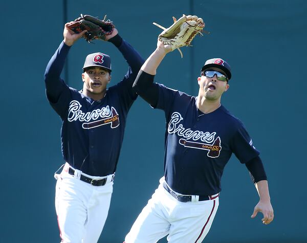 Nick Swisher (right) catches a ball in front of prospect Mallex Smith in Thursday's workout. (Curtis Compton/AJC photo)