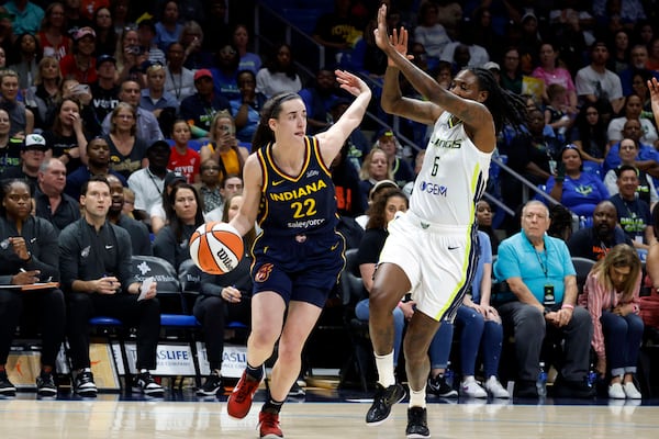 Indiana Fever guard Caitlin Clark (22) drives past Dallas Wings forward Natasha Howard (6) during the first half of an WNBA basketball game in Arlington, Texas, Friday, May 3, 2024. (AP Photo/Michael Ainsworth)