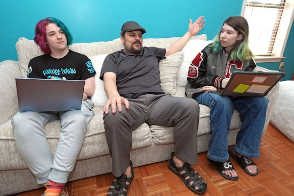 Tim Reiland, 42, center, the parent of daughter Zoe Reiland, 17, right, and Anakin Reiland, 15, photographed in Clinton, Miss., Monday, March 10, 2025, said he had no idea their previous schools, in Oklahoma, were using surveillance technology to monitor the students. (AP Photo/Rogelio V. Solis)