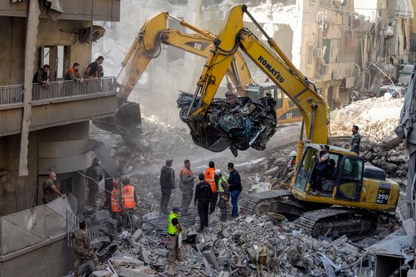 Rescue workers search for victims at the site of an Israeli airstrike that hit central Beirut, Lebanon, Saturday, Nov. 23, 2024. (AP Photo/Hassan Ammar)