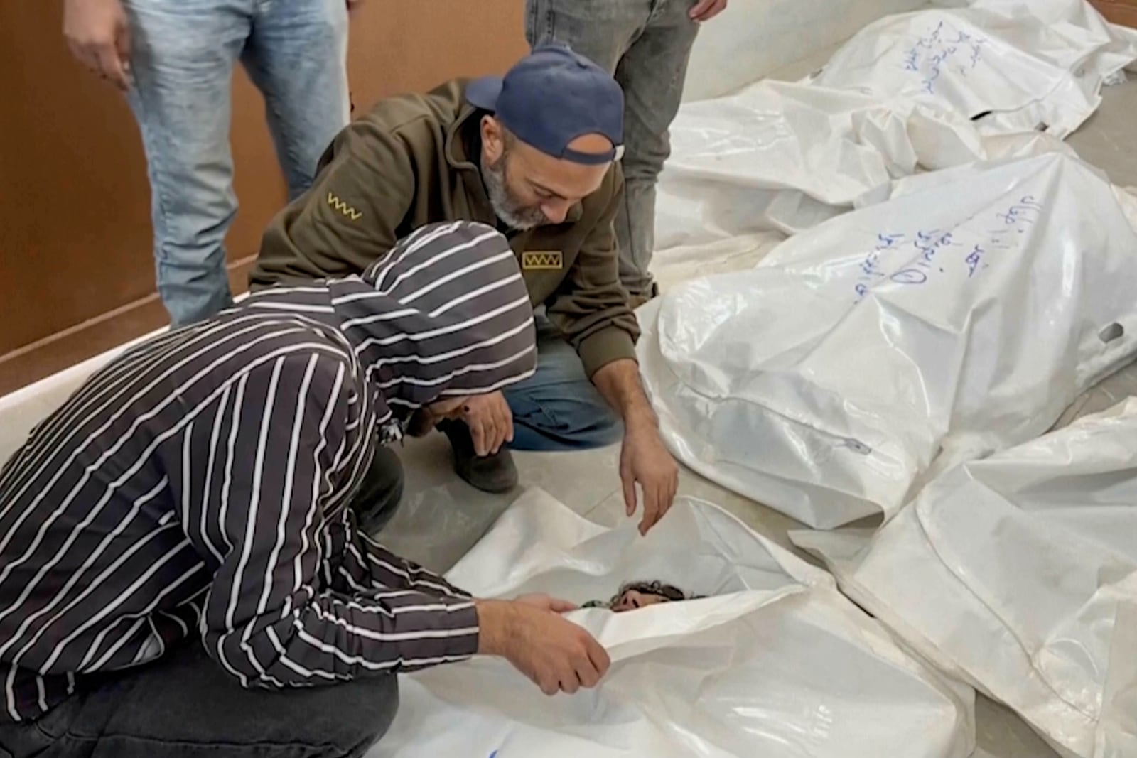 Palestinians check a body bag of a relative killed in Israeli airstrikes, in a morgue in the city of Khan Younis, southern Gaza Strip, Friday, Oct. 25, 2024. (AP Photo)