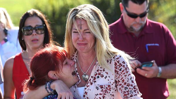 Parents wait for news after a reports of a shooting at Marjory Stoneman Douglas High School in Parkland, Fla., on Wednesday, Feb. 14, 2018. (AP Photo/Joel Auerbach)