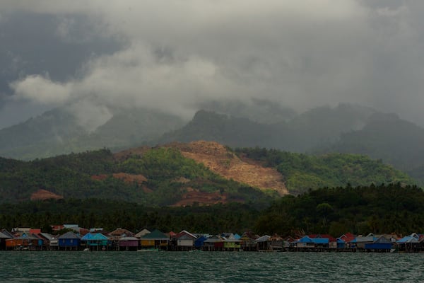 A nickel mine is visible on top of a hill above a village on Kabaena Island in South Sulawesi, Indonesia, Thursday, Nov. 14, 2024. (AP Photo/Yusuf Wahil)