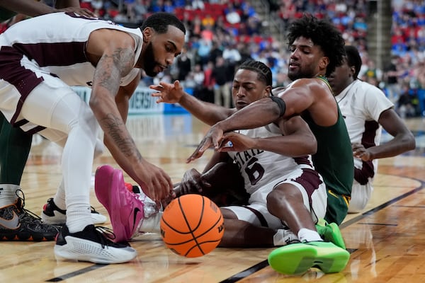 Mississippi State guard Dellquan Warren and guard Claudell Harris Jr., left, vie for a loose ball with Baylor forward Norchad Omier during the first half in the first round of the NCAA college basketball tournament, Friday, March 21, 2025, in Raleigh, N.C. (AP Photo/Chris Carlson)