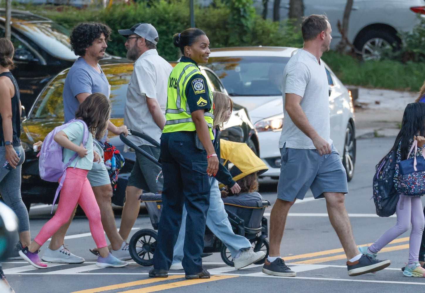 Investigator Khristia Bynum ensure a safe crossing. Parents and students arrive for the first day of school at Springdale Park Elementary School in Atlanta on Tuesday, August 1, 2023.   (Bob Andres for the Atlanta Journal Constitution)