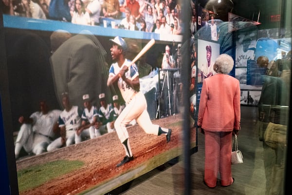 Billye Aaron looks up at photos at the entrance of the Atlanta History Center exhibit “More Than Brave: The Life of Henry Aaron” on Monday, April 8, 2024.   (Ben Gray / Ben@BenGray.com)