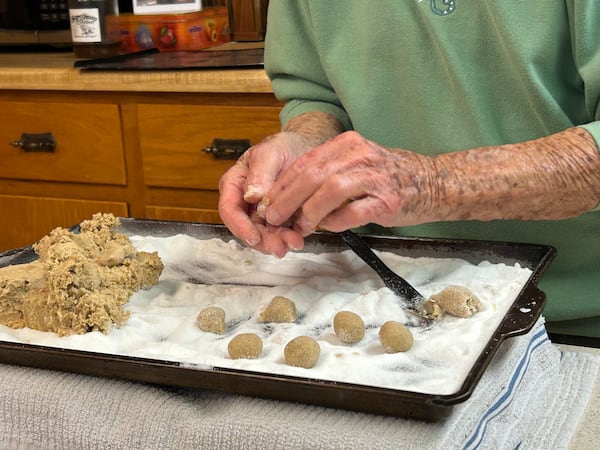 Cecilia Pruitt rolls cookie dough balls in sugar. Olivia Wakim/olivia.wakim@ajc.com