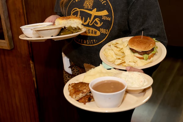 A server delivers lunch to three customers at Doug’s Place, a meat and three restaurant, on Old Allatoona Road, Thursday, November 3, 2022, in Emerson, Ga. (Jason Getz / Jason.Getz@ajc.com)