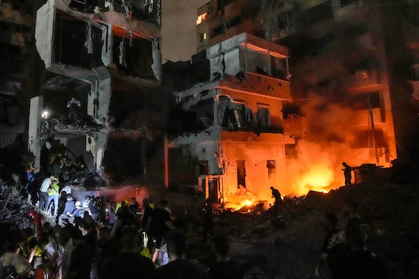 FILE - People gather in front of buildings hit by an Israeli airstrike in central Beirut, Lebanon, on Oct. 10, 2024. (AP Photo/Bilal Hussein, File)