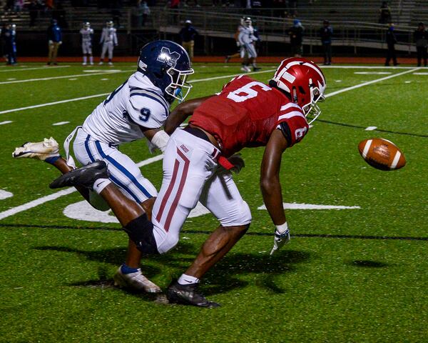 Friday Night football: Marietta's Kamryn Perry (9) and  Hillgrove's Jalen Royals (6) fight for possession of a pass in the first half of Friday's game.