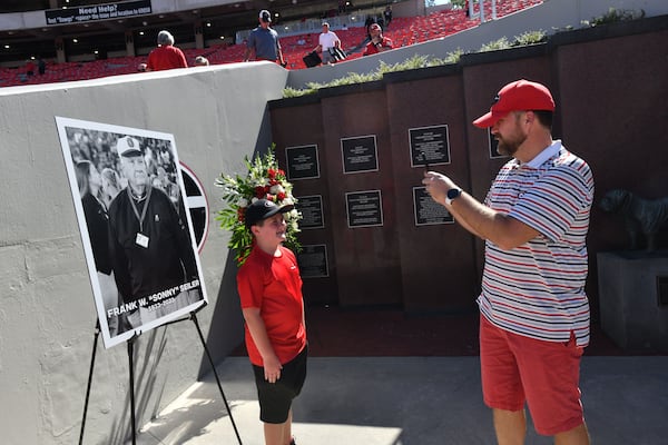 Georgia fans take their pictures in front of a memorial for the late Sonny Seiler before the home opener against UT Martin in an NCAA football game at Sanford Stadium, Saturday, September 2, 2023, in Athens. (Hyosub Shin / Hyosub.Shin@ajc.com)