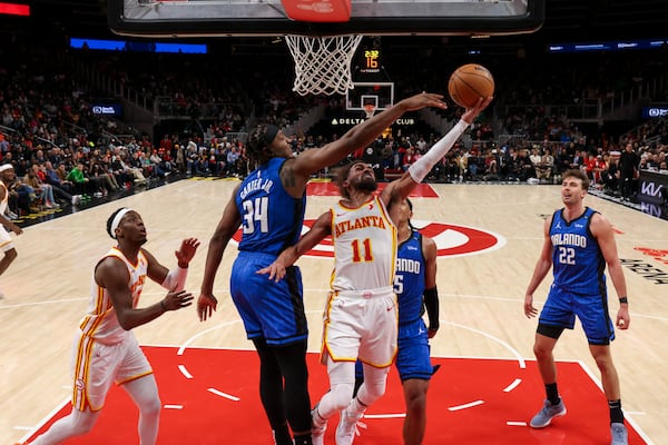 Atlanta Hawks guard Trae Young (11) attempts a shot against Orlando Magic center Wendell Carter Jr. (34) during the second half at State Farm Arena, Thursday, February, 20, 2025, in Atlanta. The Magic defeated the Hawks 114-108. (Jason Getz / AJC)