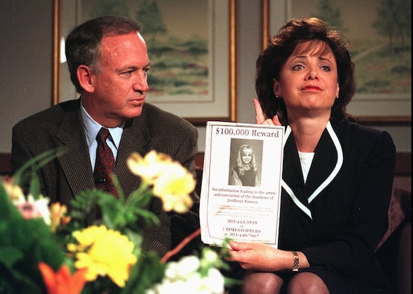 John Ramsey looks on as his wife, Patsy, holds an advertisement promising a reward for information leading to the arrest and conviction of the murderer of their 6-year-old daughter, JonBenet.