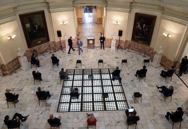 Gov. Brian Kemp passes the Right Rev. Robert Wright, bishop of the Episcopal Diocese of Atlanta, during a prayer service called by Kemp on Monday at the State Capitol.Ben@BenGray.com for The Atlanta Journal-Constitution