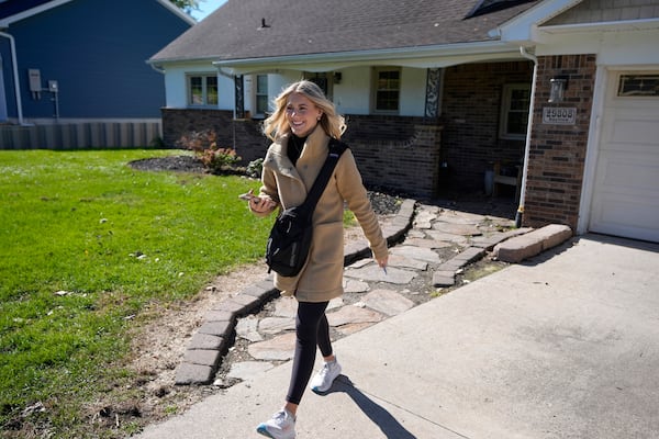 Republican Rylee Linting walks door to door campaigning hoping to unseat Democratic State Rep. Jaime Churches, Wednesday, Oct. 16, 2024, in Gibraltar, Mich. (AP Photo/Carlos Osorio)