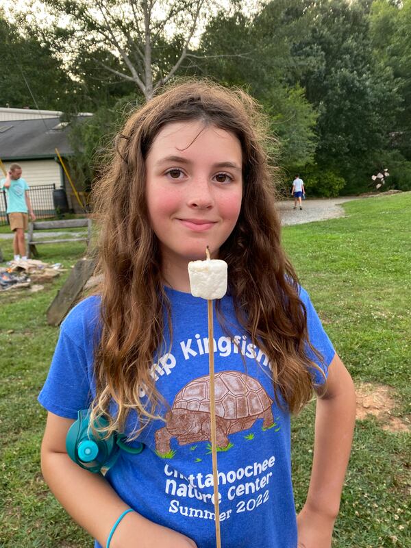 The smile of this Camp Kingfisher camper is a clear response to the question, "Who doesn’t love a roasted marshmallow at camp?" Courtesy of Chattahoochee Nature Center