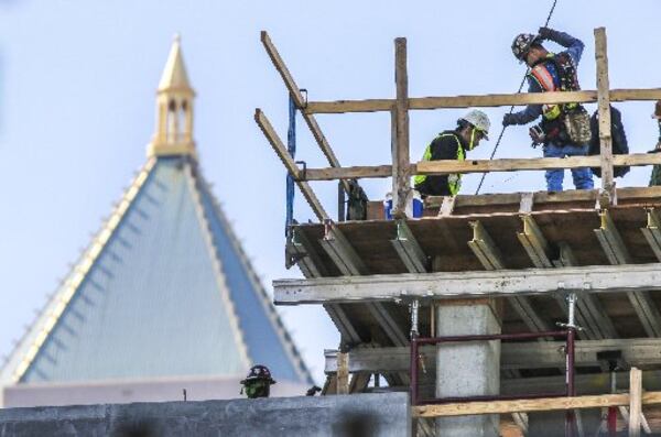 Construction continued Thursday amid summerlike temperatures on the rising apartment building, Ascent Midtown, at 1400 West Peachtree Street. JOHN SPINK / JSPINK@AJC.COM