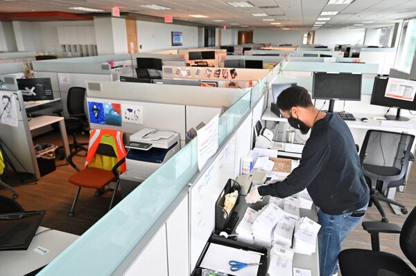 Derek Outlaw, a customer care coach, processes renewal forms in a nearly empty customer care center at Gas South headquarters in metro Atlanta. Shoppers are hitting stores and filling parking lots. Some diners are returning to sit-down restaurants. But many of metro Atlanta’s white-collar towers and office parks are still lonely places during the coronavirus pandemic. The restart of the economy is often doing so without a big return to cubicles, shared desks and many of the other trappings of corporate life. (Hyosub Shin / Hyosub.Shin@ajc.com)