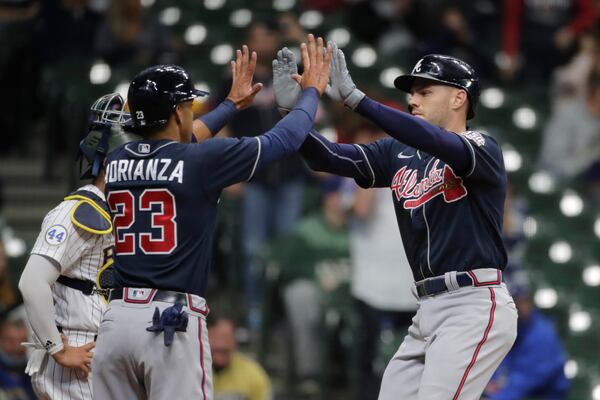 Atlanta Braves' Freddie Freeman is congratulated by Ehire Adrianza (23) during the second inning of the team's baseball game against the Milwaukee Brewers on Saturday, May 15, 2021, in Milwaukee. (AP Photo/Aaron Gash)