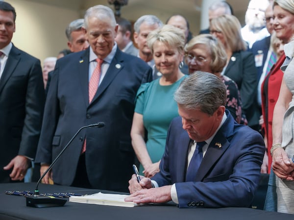 With much fanfare, Gov. Brian Kemp signs HB 1013, which aims to increase access to mental health coverage in Georgia on Sine Die, the last day of the General Assembly at the Georgia State Capitol in Atlanta on Monday, April 4, 2022.   (Bob Andres / robert.andres@ajc.com)