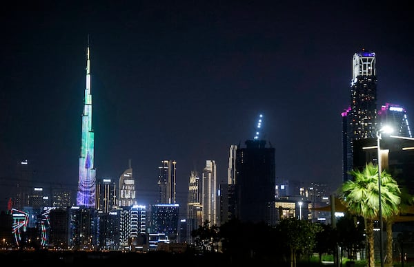 A picture shows a general view of the Dubai skyline at night, including the Burj Khalifa (left), the world's tallest building, on Dec. 1, 2023. (Ludovic Marin/AFP via Getty Images/TNS)