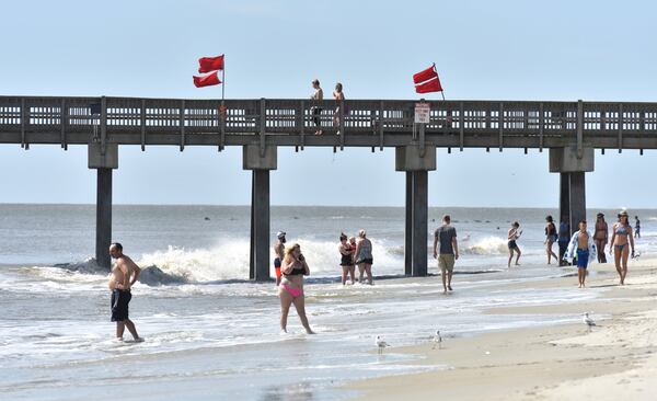 Beachgoers enjoy themselves on Tybee Island despite the risk of rip tides making swimming dangerous as Tropical Storm Florence roils the Carolinas on September 14, 2018. 