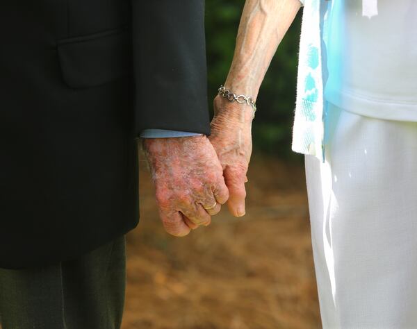 Jimmy and Rosalynn Carter hold hands as they leave the Maranatha Baptist Church following church services in Plains in 2014. (Curtis Compton / ccompton@ajc.com)