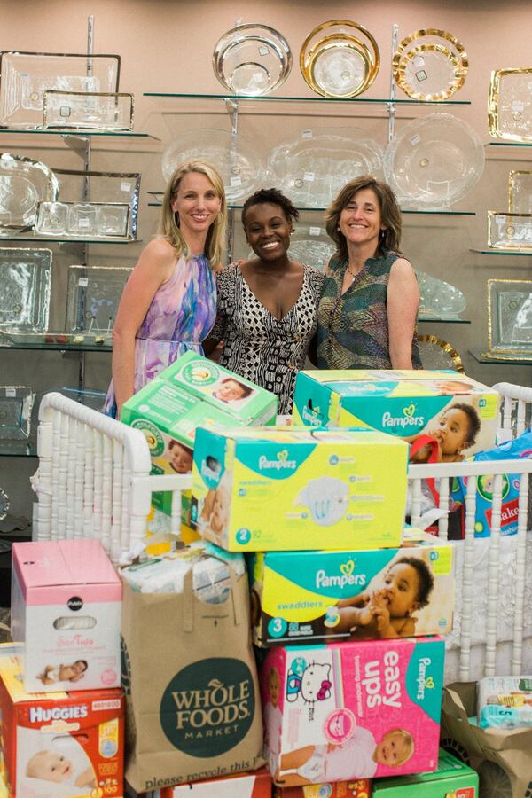 Brooke Henze, owner of Swell Forever, pictured left with Ayzsa Tannis from Helping Mamas and Jean Christian, shows off diapers collected at a fundraiser held Thursday. More than 3,500 diapers were donated to local moms in need and $1,000 to help babies of Syrian refugees. CONTRIBUTED BY STEPHANIE MADISON PHOTOGRAPHY