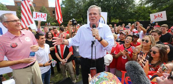 Lt. Governor Casey Cagle looks on as GOP Presidential Candidate Jeb Bush works a crowd of Georgia and South Carolina tailgaters before the football game on Saturday, Sept. 19, 2015, in Athens. Curtis Compton / ccompton@ajc.com