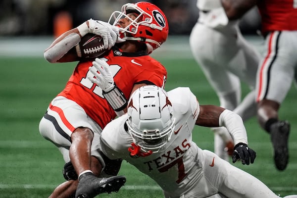 Texas defensive back Jahdae Barron (7) hits Georgia wide receiver Arian Smith (11) during the second half of the Southeastern Conference championship NCAA college football game, Saturday, Dec. 7, 2024, in Atlanta. (AP Photo/Mike Stewart)