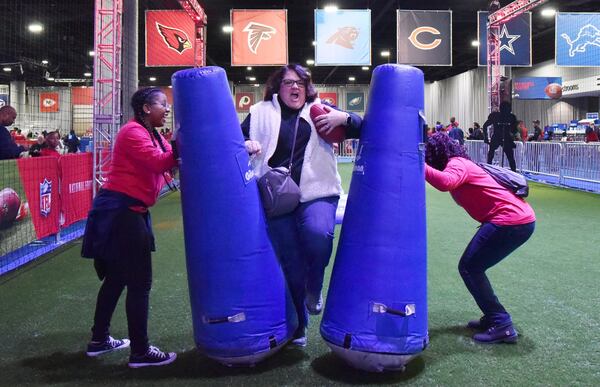 Michelle Baker, of Raleigh, NC, shows her game face as she plays a quick slant game during the Super Bowl Experience in the Georgia World Congress Center on Saturday. HYOSUB SHIN / HSHIN@AJC.COM