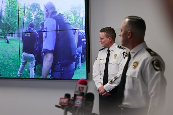 (Left to right) Cobb County Police Chief Stuart VanHoozer and Captain Darin Hull watch video of the arrest of the Midtown shooter during a news conference at Cobb County Police Headquarters on Tuesday. (Natrice Miller/natrice.miller@ajc.com)