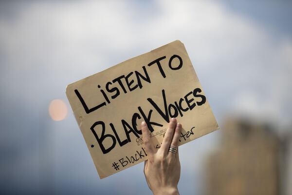 05/29/2020 - Atlanta, Georgia - A peaceful protestor carries a sign during a march from Centennial Olympic Park to the Georgia State Capitol building in Atlanta, Friday, May 29, 2020. (ALYSSA POINTER / ALYSSA.POINTER@AJC.COM)