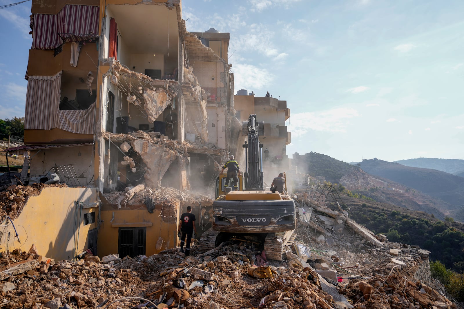 Rescue workers use excavators to remove the rubble of a destroyed building that was hit Tuesday night in an Israeli airstrike, as they search for victims in Barja, Lebanon, Wednesday, Nov. 6, 2024. (AP Photo/Hassan Ammar)