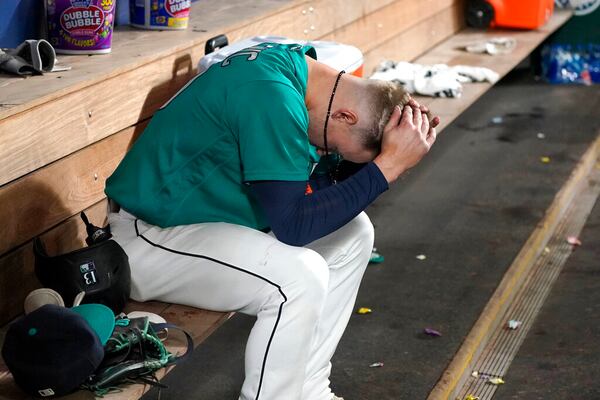 Seattle Mariners' Jarred Kelenic sits in the dugout after he flew out against the Los Angeles Angels to end the ninth inning of a baseball game against the Los Angeles Angels, Friday, Oct. 1, 2021, in Seattle. The Angels won 2-1. (AP Photo/Ted S. Warren)