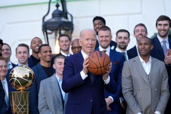 President Joe Biden holds the ball he was presented with by the Boston Celtics during an event to celebrate the Celtics' victory in the 2024 National Basketball Association Championship, on the South Lawn of the White House in Washington, Thursday, Nov. 21, 2024. (AP Photo/Susan Walsh)